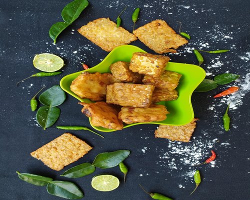 A plate of traditional Indonesian homemade food with rice, tempeh, and vegetables