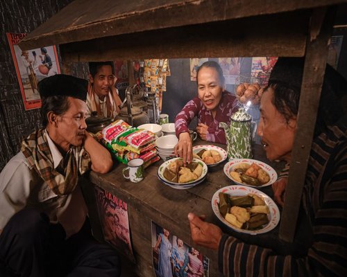 A busy traditional food stall (warung) in Indonesia with people enjoying their lunch break